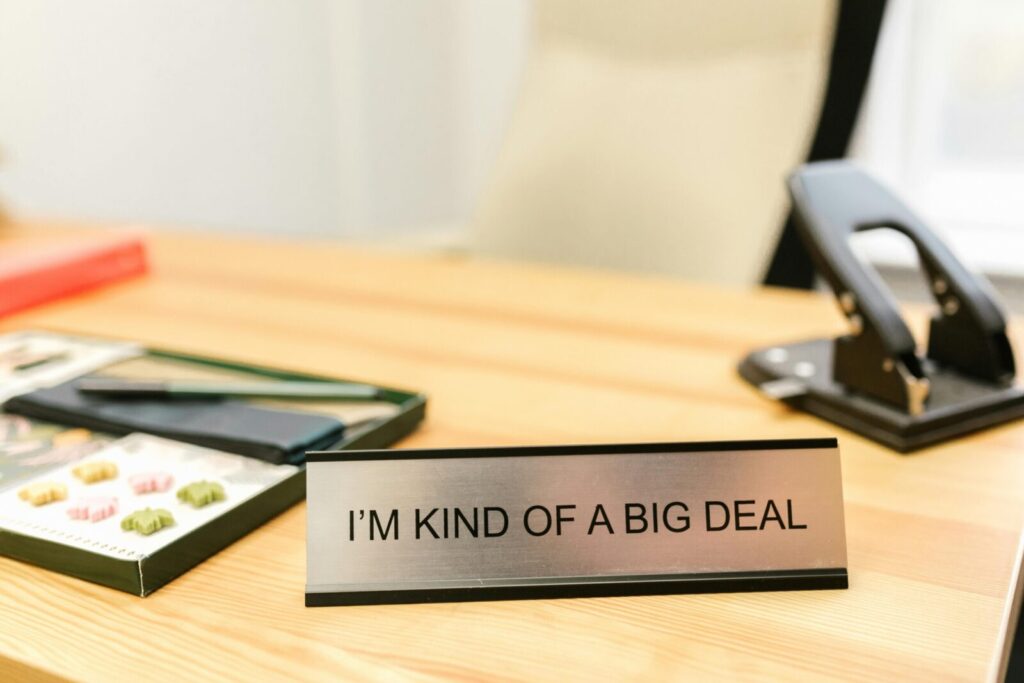A desk sign with the phrase 'I'm Kind of a Big Deal' in an office setting, showcasing humor.