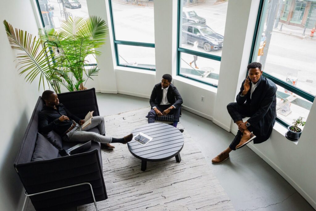 Three businessmen engaging in a professional meeting in a stylish office setting.